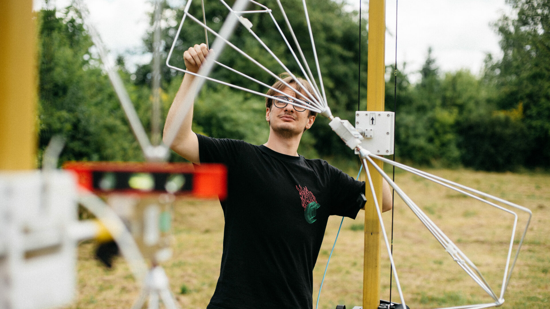 Pracownik laboratorium podczas pomiarów anten na otwartym terenie.
